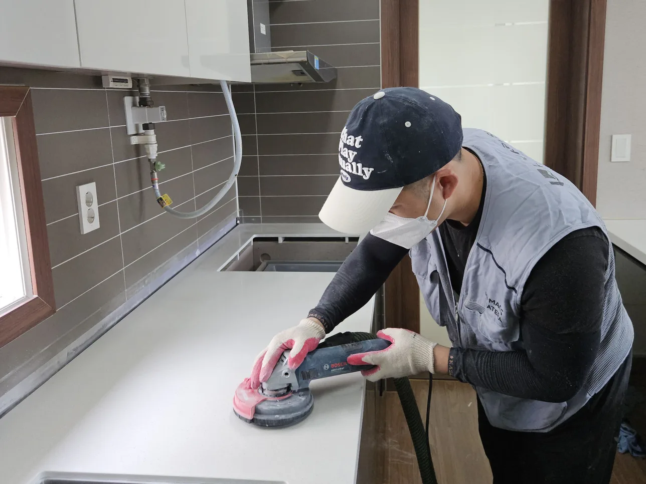 새로 시공한 싱크대 상판을 그라인더로 직접 다듬는 모습